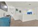 Upstairs hallway featuring a blue dresser and coastal artwork, leading to various rooms with white doors at 15613 Camp Dubois Cres, Winter Garden, FL 34787