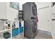 Functional laundry room featuring stacked washer and dryer, storage shelves, and ample space at 15613 Camp Dubois Cres, Winter Garden, FL 34787
