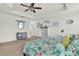Comfortable primary bedroom with tropical-themed bedding, a ceiling fan, and coordinating blue furnishings at 15613 Camp Dubois Cres, Winter Garden, FL 34787