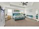 Spacious primary bedroom featuring a ceiling fan, large windows, and blue bed with tropical bedding and decor at 15613 Camp Dubois Cres, Winter Garden, FL 34787