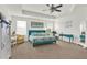 Spacious primary bedroom featuring a ceiling fan, large windows, and blue bed with tropical bedding and decor at 15613 Camp Dubois Cres, Winter Garden, FL 34787