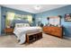 Charming bedroom with wood furnishings and soothing blue walls creating a comfortable retreat at 1921 Geronimo Trl, Maitland, FL 32751
