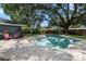 Backyard pool featuring brick patio, mature tree, and fenced yard at 1921 Geronimo Trl, Maitland, FL 32751