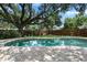 Refreshing in-ground pool surrounded by lush greenery and a brick patio at 1921 Geronimo Trl, Maitland, FL 32751