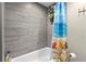 Modern shower with gray wood-look tile and bright shower curtain at 1921 Geronimo Trl, Maitland, FL 32751