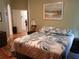 Bedroom with hardwood floors, a tropical-patterned comforter, and an adjacent doorway at 2474 Cimmaron Ash Way, Apopka, FL 32703