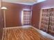 Empty bedroom with wine-themed curtains, wood floors, and neutral walls, ready for personalization at 2474 Cimmaron Ash Way, Apopka, FL 32703