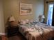 Comfortable bedroom with matching nightstands, lamps, and tropical patterned comforter, next to an outdoor view at 2474 Cimmaron Ash Way, Apopka, FL 32703