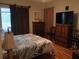 Bedroom with hardwood floors, a tropical-patterned comforter, and wooden furniture at 2474 Cimmaron Ash Way, Apopka, FL 32703