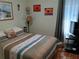 Cozy bedroom with wood floors, a queen-sized bed, decorative pillows, and artwork at 2474 Cimmaron Ash Way, Apopka, FL 32703