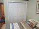 Bedroom featuring a bi-fold closet, soft bedding, and a view into the hallway at 2474 Cimmaron Ash Way, Apopka, FL 32703