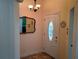 Inviting foyer featuring tile flooring, a decorative mirror, and an ornate front door at 2474 Cimmaron Ash Way, Apopka, FL 32703