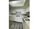 A functional kitchen with white cabinets and appliances, and modern laminate flooring at 2520 Caper Ln # 206, Maitland, FL 32751