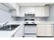 Kitchen with white cabinetry, appliances, and a stainless steel sink at 2520 Caper Ln # 206, Maitland, FL 32751