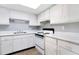 Bright kitchen with white cabinets, countertops, tile floors and an electric range at 2520 Caper Ln # 206, Maitland, FL 32751
