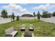 Landscaped backyard featuring a fire pit, seating area, and a white picket fence at 267 Williamson Dr, Davenport, FL 33897