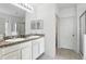 Well-lit bathroom with double sinks, granite countertops, and access to the walk-in shower at 267 Williamson Dr, Davenport, FL 33897