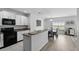 Modern kitchen with white cabinetry, eat-in bar, and views of the dining area at 267 Williamson Dr, Davenport, FL 33897