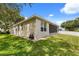 Well-maintained home exterior with lush green lawn, screened-in porch, and white fenced backyard at 2696 Clearview St, Clermont, FL 34711