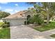 Charming single-story home featuring a well-maintained lawn, mature trees, and an attached two-car garage at 2696 Clearview St, Clermont, FL 34711