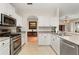 Bright kitchen with white cabinets, stainless steel appliances, and neutral countertops, offering a clean design at 2696 Clearview St, Clermont, FL 34711
