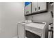 Modern laundry room with front-load washer and dryer, upper cabinets and ladder at 2696 Clearview St, Clermont, FL 34711