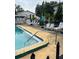 Community pool area with lounge chairs, umbrellas, and well-maintained concrete deck and safety fence at 2776 Curry Ford Rd # Ge, Orlando, FL 32806