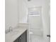 Well-lit bathroom featuring neutral tile, a vanity with a dark base, and a white sink and toilet at 2926 Sailhouse Drive, St Cloud, FL 34771