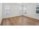 Sun-lit bedroom with natural wood floors and three bright windows with modern blinds at 2926 Sailhouse Drive, St Cloud, FL 34771