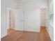 Bright bedroom featuring hardwood floors, white walls, and closet access for a clean and modern aesthetic at 2926 Sailhouse Drive, St Cloud, FL 34771