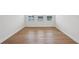 Bright bedroom featuring wood floors, three windows, and pristine white walls at 2926 Sailhouse Drive, St Cloud, FL 34771
