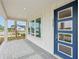 Inviting covered front porch with stylish brick flooring and a modern blue front door, perfect for relaxing outdoors at 2926 Sailhouse Drive, St Cloud, FL 34771
