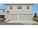 Front facade with a two-car garage, adjacent entrance, and classic exterior lighting enhancing curb appeal at 2926 Sailhouse Drive, St Cloud, FL 34771