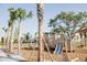 Community playground with modern equipment, lush landscaping, and shaded seating area at 2926 Sailhouse Drive, St Cloud, FL 34771