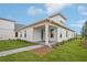 Attractive rear exterior showcasing a covered patio, well-maintained lawn, and complementing neutral color scheme at 2926 Sailhouse Drive, St Cloud, FL 34771