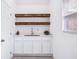 A bar area with white cabinets, shelves, stainless steel sink, and modern faucet at 3007 Knollwood Cir, Orlando, FL 32804