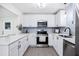 Modern kitchen with stainless steel appliances, quartz countertops, stylish gray backsplash, and white cabinetry at 3007 Knollwood Cir, Orlando, FL 32804