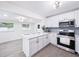 Modern kitchen features stainless steel appliances, quartz countertops, stylish gray backsplash, and white cabinetry at 3007 Knollwood Cir, Orlando, FL 32804