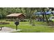 Community area featuring a wooden pavilion, playground, and barbeque grills surrounded by lush landscaping and green space at 3222 Reserve Ct, Orlando, FL 32825
