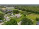 An aerial view showcases the property, surrounded by a verdant lawn, driveway and some trees at 3779 N Econlockhatchee Trl, Orlando, FL 32817