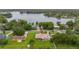 An aerial view shows a home near a lake, surrounded by lush greenery and other residential properties at 3779 N Econlockhatchee Trl, Orlando, FL 32817
