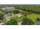 An aerial view showcases the property, surrounded by a verdant lawn, driveway and some trees at 3779 N Econlockhatchee Trl, Orlando, FL 32817