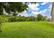 The large grassy backyard is complimented by mature trees and landscaping at 3779 N Econlockhatchee Trl, Orlando, FL 32817