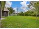 A spacious backyard shows off a grassy lawn, partial fencing, and a screened-in porch at 3779 N Econlockhatchee Trl, Orlando, FL 32817