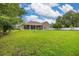 The large backyard shows the home's screened in porch, manicured lawn and partial perimeter fencing at 3779 N Econlockhatchee Trl, Orlando, FL 32817