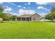 The expansive grassy backyard leads to the home's covered, screened-in porch at 3779 N Econlockhatchee Trl, Orlando, FL 32817