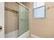 Bathroom with a tiled shower, glass sliding door, and a window for natural light at 3779 N Econlockhatchee Trl, Orlando, FL 32817