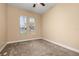 Light-filled bedroom with neutral carpet, ceiling fan, and two windows offering views and sunlight at 3779 N Econlockhatchee Trl, Orlando, FL 32817