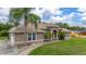 Side view of a single-story home featuring a lawn, driveway, and lush surroundings at 3779 N Econlockhatchee Trl, Orlando, FL 32817