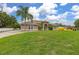 Inviting single-story home with lush green lawn and mature palm trees in a serene setting at 3779 N Econlockhatchee Trl, Orlando, FL 32817